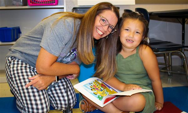 A teacher and student smile for a photo